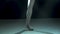 Graceful legs of a ballerina in pointe shoes. Shot in a darkness on spotlights background of studio. Ballerina shows