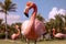 Graceful pink flamingo on lush lawn near exotic palm trees