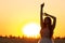 Graceful silhouette figure of young woman walking in field at sunset, beautiful romantic girl with long hair outdoors