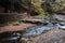 Graceful waterfalls flow around a stone walkway and bridge