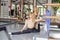 Graceful young blonde woman stretching her body, doing pilates workout with her instructor in studio