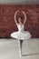 Graceful young talented ballerina standing on toes and looking aside