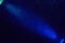 Gradient blue beam of light on dark blue grainy background