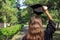 Graduate celebrating with a cap in her hand,feeling so proud and happy in graduation day