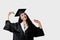 Graduate girl with master degree in black graduation gown and cap on white background. Happy young woman careerist have