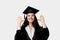 Graduate girl with master degree in black graduation robe and cap on white background. Happy young woman careerist have