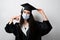 Graduate girl in medical mask at coronavirus covid-19 period. Woman with master degree in black graduation gown and cap