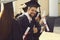 Graduate student with the diploma and in the black academic gown raises his thumbs up.