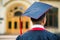 Graduate student hands holding diploma from the back