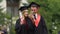 Graduate students in academic dresses taking selfies after graduation ceremony