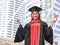 Graduated woman in graduation gowns holding diploma and raise fist, smiling happily. City building background. Education and