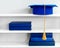 Graduation blue mortarboard on top of stack of books on wooden shelf