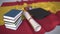 Graduation cap, books and diploma on the Spanish flag. Higher education in Spain related conceptual 3D rendering