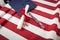 Graduation Cap and Diploma Resting on American Flag