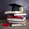 A Graduation cap, hat placed on a stack of books on the table.