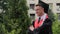 Graduation ceremony, cheerful student posing for camera with folded arms