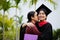 Graduation ceremony. Young female graduate hugging each other with her mother congratulate the student at the university