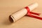 Graduation diploma tied with red ribbon on wooden table, closeup