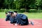 Graduation group of students celebrating on athletic track, prep