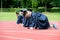 Graduation group of students celebrating on athletic track, prep