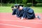 Graduation group of students celebrating on athletic track, prep