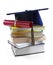 Graduation hat and diploma on stack of books