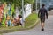 Graffiti artist working on a design on a wall next to a path