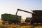 Grain auger of combine pouring wheat into tractor trailer