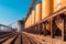 Grain deal concept, metal grain storage stands close up to rail ways