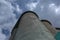 Grain elevator against a stormy sky. Large factory structure against a blue sky, low angle view