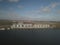 Grain elevator in the port on the river bank. Huge stainless steel tanks for storing crops. Aerial drone or quadrocopter aerial vi