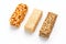 Grain granola bar with peanuts, sesame and seeds in a row on a white background. Top view Three assorted bars, isolate