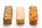 Grain granola bar with peanuts, sesame and seeds in a row on a white background. Top view Three assorted bars, isolate