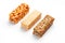 Grain granola bar with peanuts, sesame and seeds in a row on a white background. Top view Three assorted bars, isolate