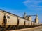 Grain hopper cars of the NS railroad being loaded with grain.