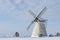 Grain mill on the winter landscape. Dutch windmill and natural background pattern.