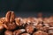 Grains of black coffee on a black granite countertop with yellow light from behind. Advertising photo of coffee.