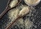 Grains of cereal rice on a dark background in a jar next to wooden spoon