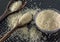 Grains of cereal rice on a dark background in a jar next to wooden spoon