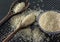 Grains of cereal rice on a dark background in a jar next to wooden spoon