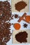 Grains of coffee and slices of dried oranges are scattered on the surface of the table. Cinnamon sticks and anise are also visible