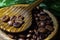 Grains of coffee in a wooden spoon, closeup on the beans of coffee, on the wood table texture