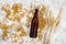 Grains of malting barley near beer glass and bottle on grey background top view