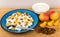 Grainy curd with peaches and raisins, bowl with sour cream