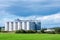 Granary large modern agro-processing plant storage and processing of grain crops. Large metal barrels of grain.Summer cloudy day