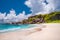 Grand Anse exotic beach at La Digue island in Seychelles. White sandy beach with blue ocean lagoon, white waves and