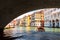 Grand Canal in summer, Venice, Italy. Motor boat sails under famous Rialto Bridge, landmark of Venice