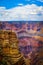 The Grand Canyon - Magnificent vertical view of Colorado River running through the depths with late afternoon sun highlighting the