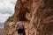 Grand Canyon - Rear view of woman with backpack hiking through carved tunnel along Bright Angel trail, Arizona