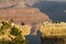 Grand Canyon tourist sits on a ledge at sunrise